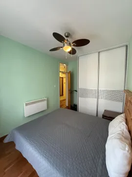 Bedroom with a double bed, wardrobe, and ceiling fan. - image 8