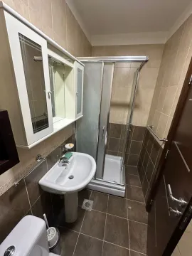 A bathroom with a shower cabin and sink. - image 19