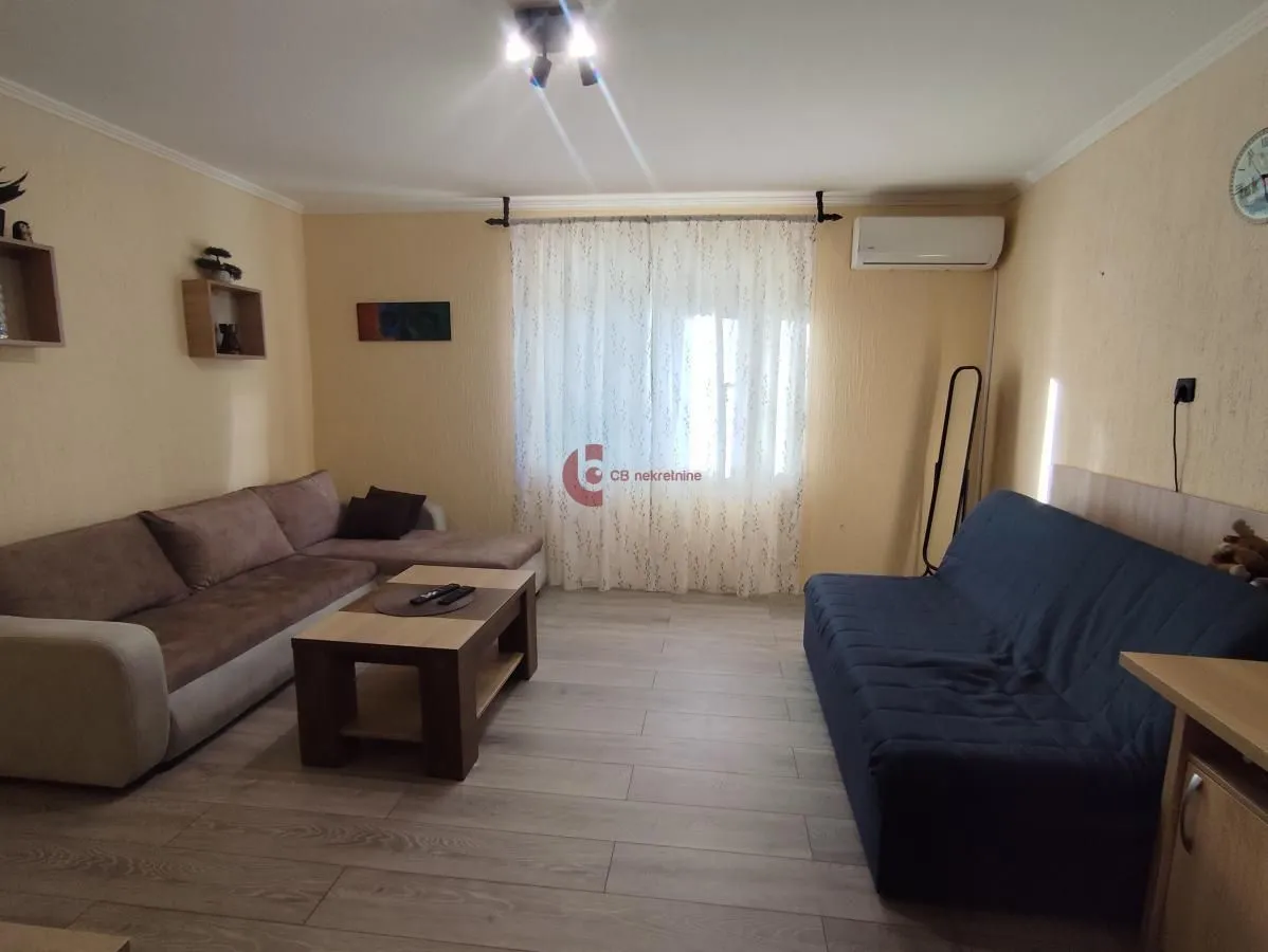 Dnevna soba sa garniturom za sedenje i stočićem.