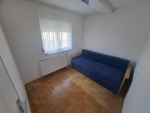 Manja spavaća soba sa plavim kaučem i parketom. - image 8