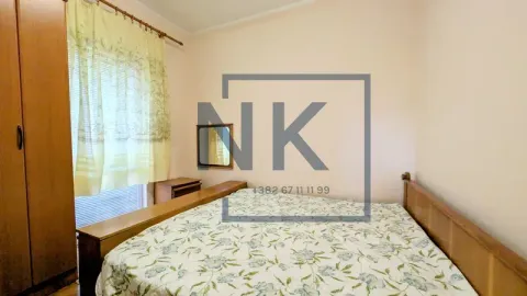 Furnished bedroom with a double bed, wooden wardrobe, and a window. - image 3