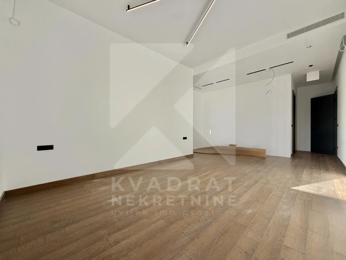 Empty room with hardwood flooring and white walls.