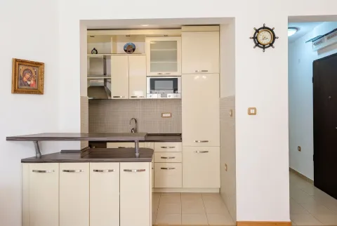 Kitchen equipped with light cabinetry and a breakfast bar. - image 11