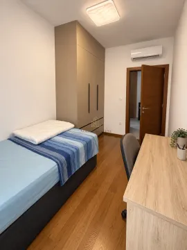 Smaller bedroom with a bed, wardrobe, and a desk. - image 10