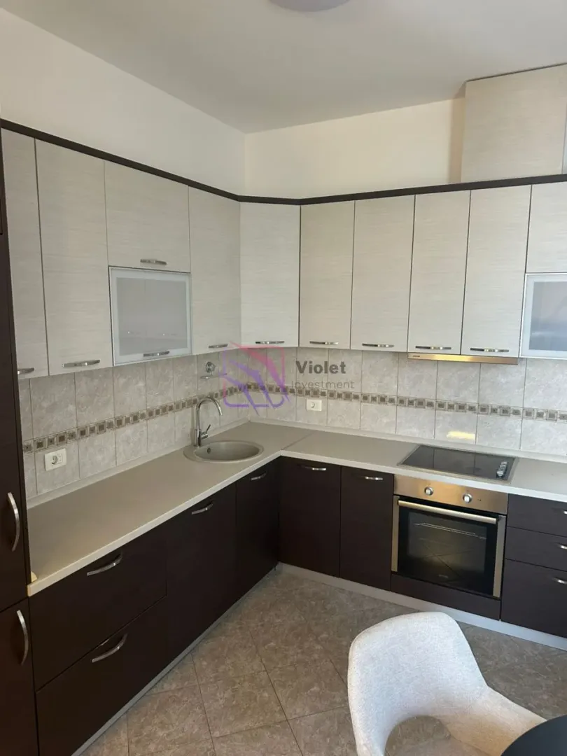 Kitchen equipped with lower and upper cabinets, built-in oven, and hob.