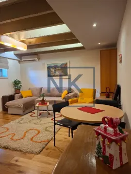 Living room with sofa, dining table, and decorative ceiling beams. - image 3