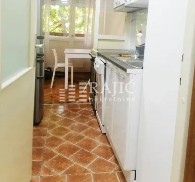 Small kitchen with a dining table and terrace access. - image 5