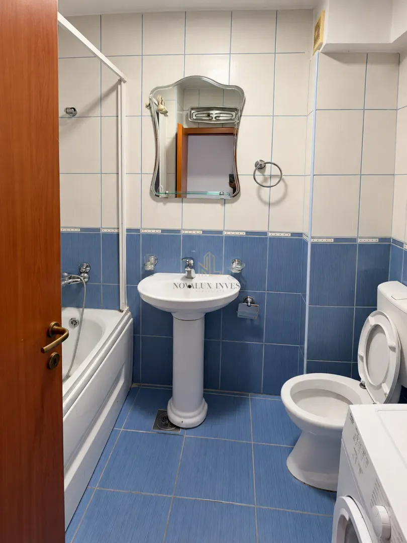 Bathroom equipped with a bathtub, washbasin, toilet, and a mirror.