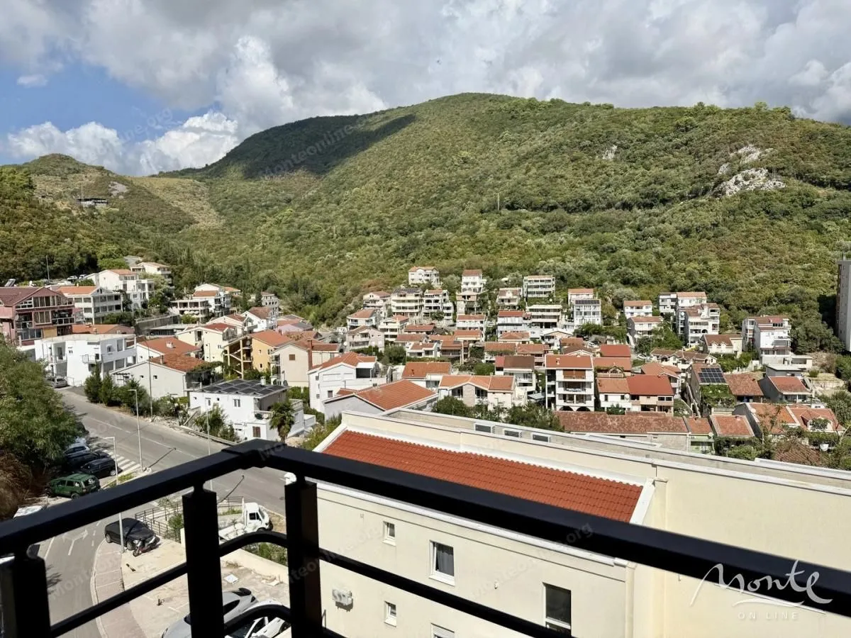 Pogled sa terase na naselje i zelena brda.