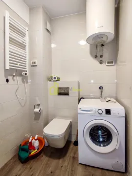 Bathroom equipped with a toilet, washing machine, and water heater. - image 14