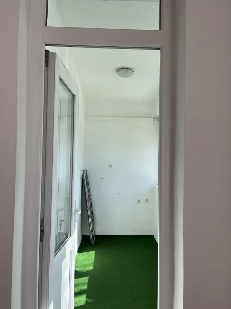 View through a door onto a balcony with artificial grass.