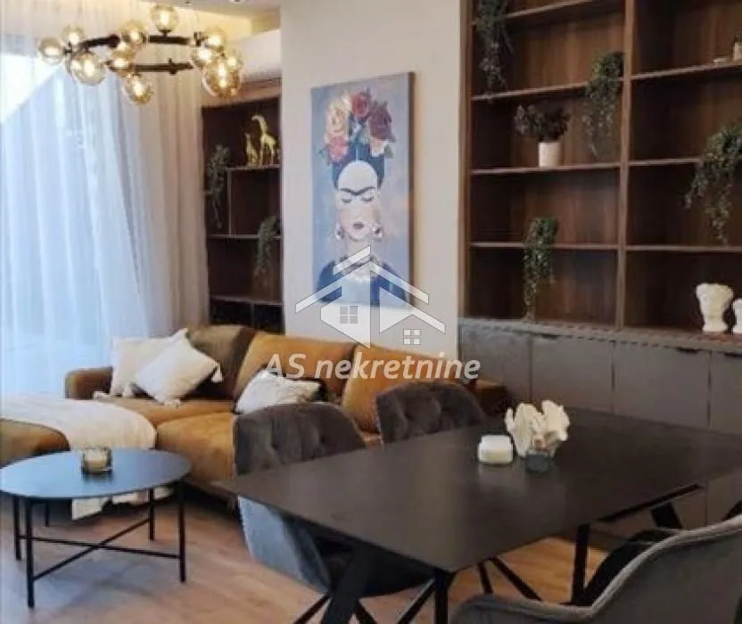 Living room with dining area, sofa set, large shelving units, and decorative lighting.