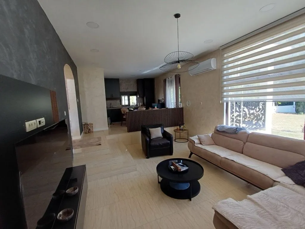 Spacious living room with a sofa set and a view towards the dining area and kitchen.