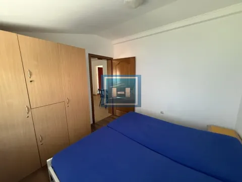 Spavaća soba sa krevetom i drvenim ormarom. - image 4