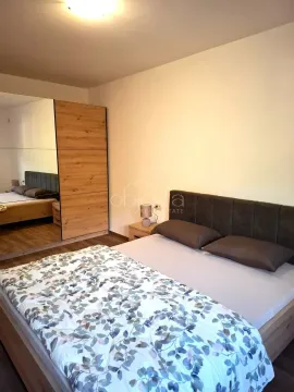 Furnished bedroom with a double bed, nightstand, and a large mirrored wardrobe. - image 8
