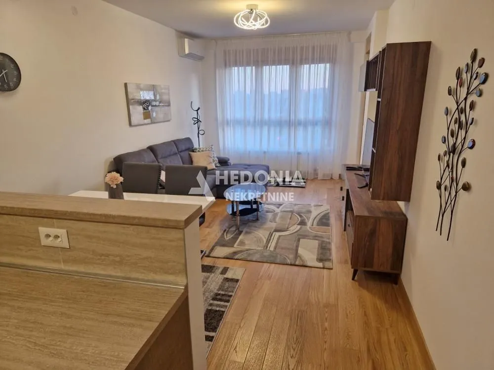 Living room with sofa, TV unit and dining table.