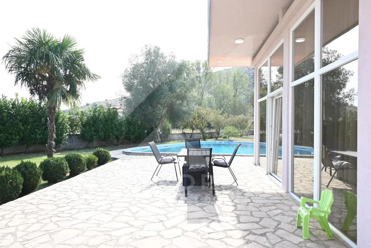 Terrace with seating furniture and a view of the pool and yard.