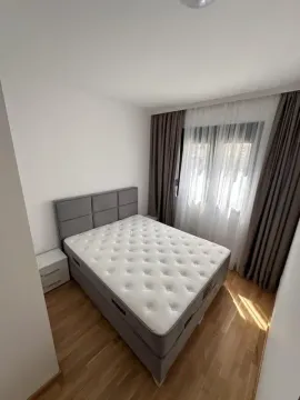 Svjetla spavaća soba sa bračnim krevetom, bijelim noćnim ormarićima i prozorom sa zavjesama. - image 5