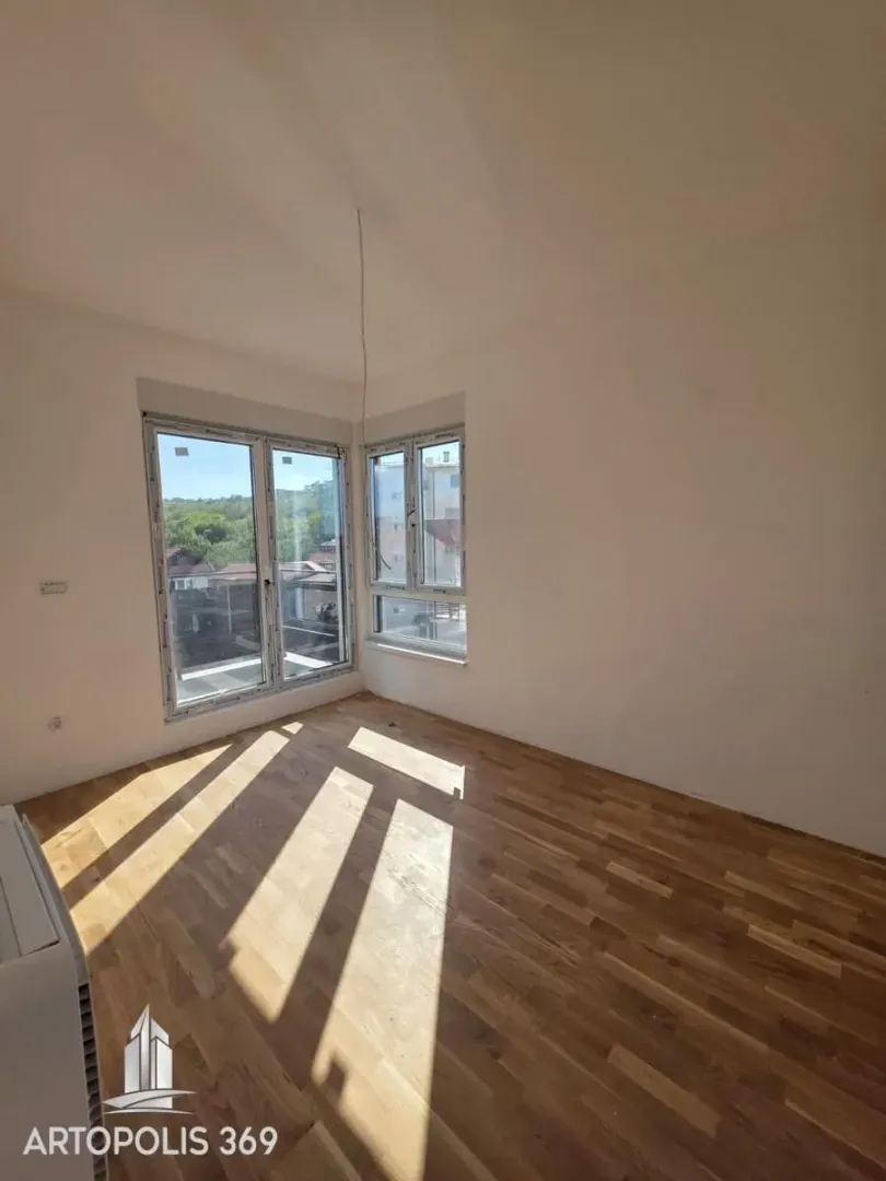 Empty room with hardwood floors and windows.