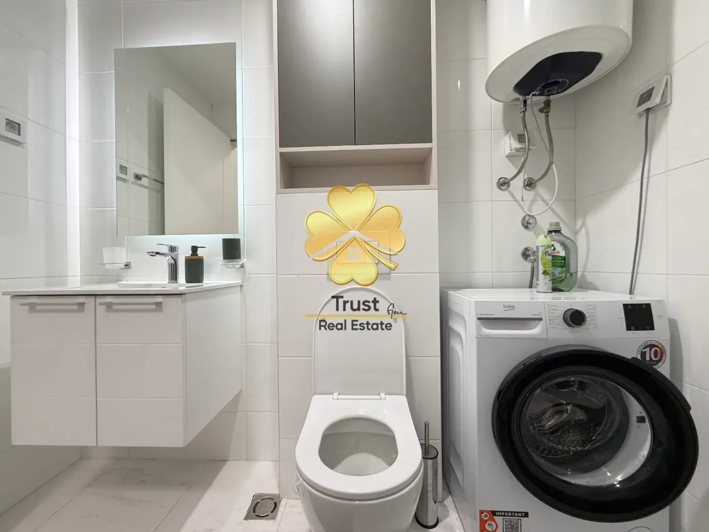 Modern bathroom equipped with a washing machine and white sanitary fixtures.