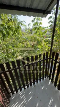 Natkriven balkon sa drvenom ogradom i pogledom na zelenilo. - image 2