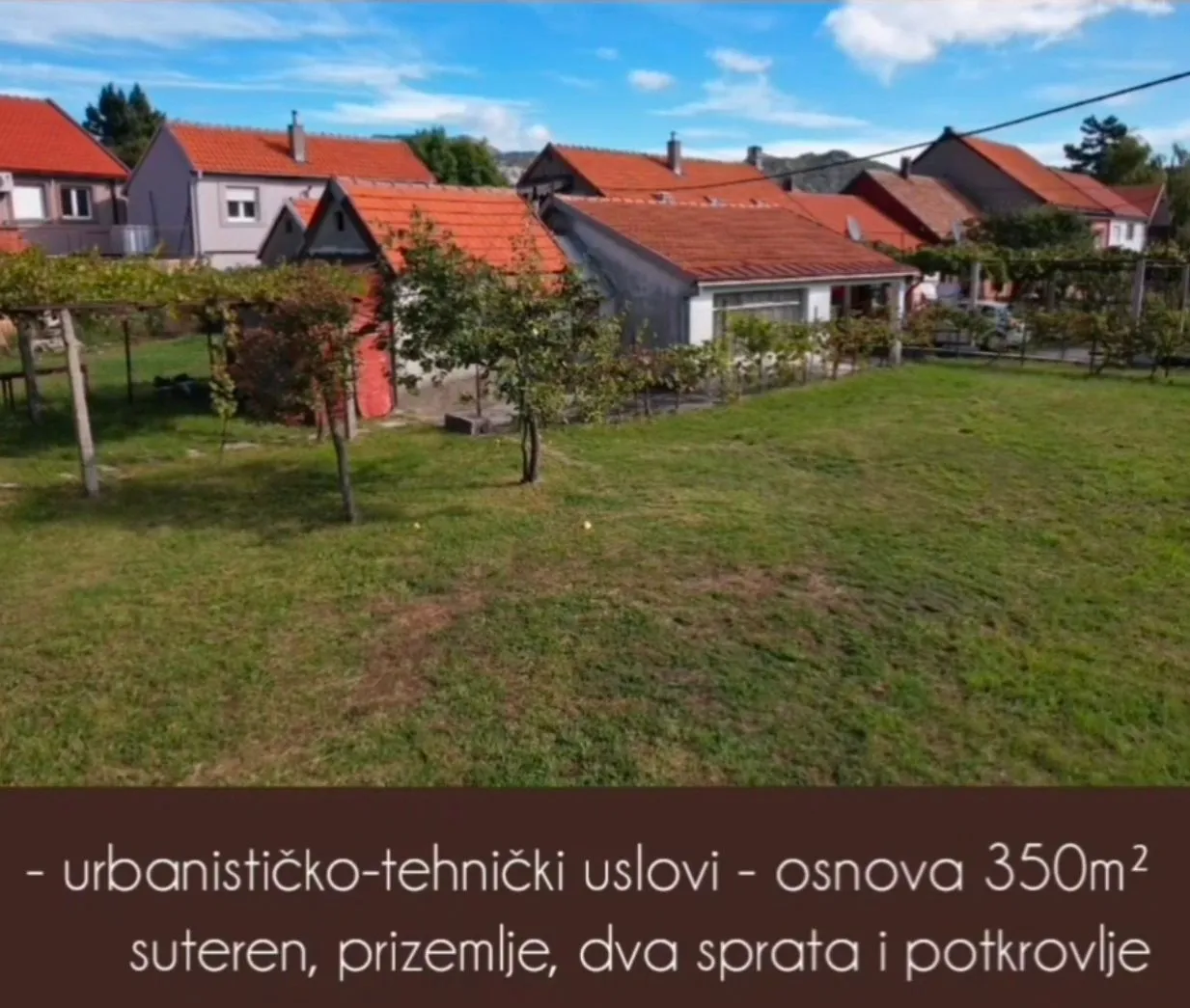 Pogled na dvorište i kuće sa narandžastim krovovima.