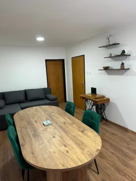 Dnevna soba sa trpezarijskim stolom, zelenim stolicama i garniturom. - image 10
