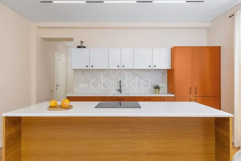 Modern kitchen with an island, built-in cooktop, and a combination of orange and white cabinets. - image 6