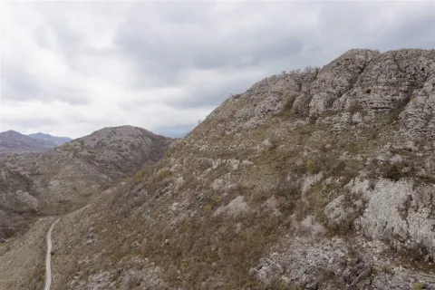 Pogled na prostrani brdoviti teren i krševiti pejzaž pod oblačnim nebom. - image 11