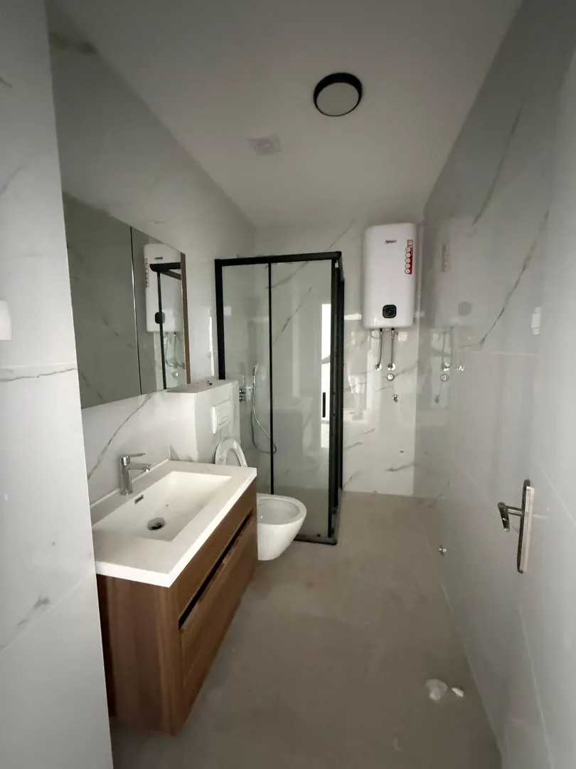 Moderne kupatilo sa umivaonikom, tuš kabinom i bojlerom.