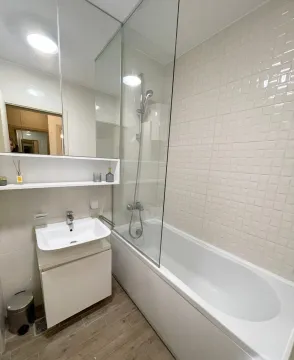 Modern bathroom with bathtub, glass screen and washbasin. - image 5