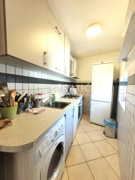 Smaller white kitchen with cabinets and built-in appliances. - image 10