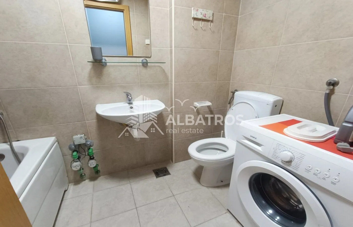 Bathroom equipped with sanitary ware, washbasin, bathtub, and washing machine.