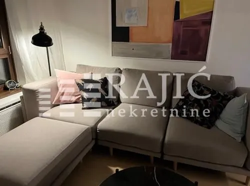 Living room with a comfortable sectional sofa and an artwork on the wall.