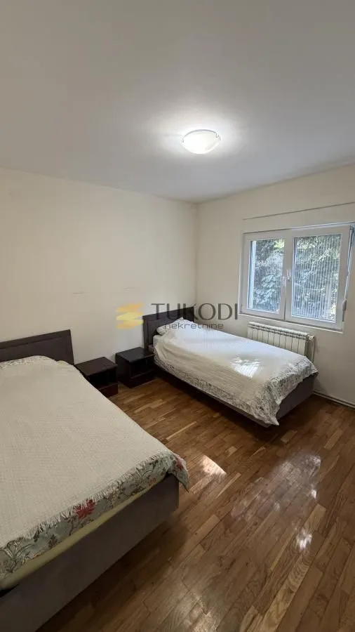 Bedroom with two single beds and parquet flooring.