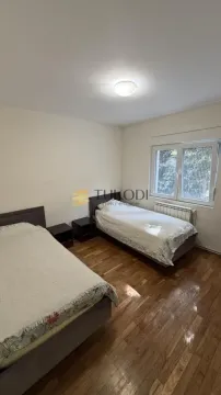 Bedroom with two single beds and parquet flooring. - image 14