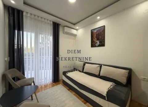 Living room with a sofa, coffee table, and balcony doors. - image 9