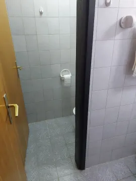A view through an open doorway into a bathroom with white tiled walls. - image 7