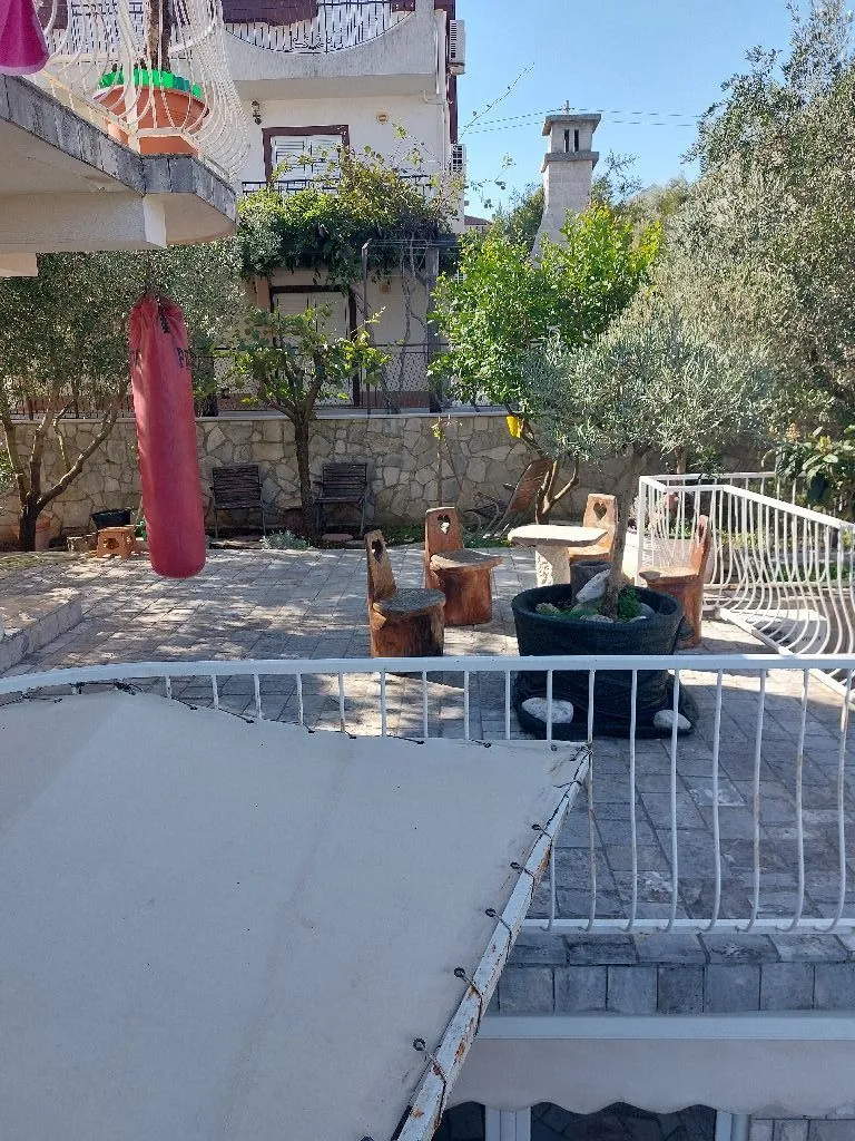 Popločano dvorište sa garniturom za sjedenje i zelenilom.