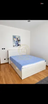 Spavaća soba sa bračnim krevetom i umetničkom slikom na zidu. - image 3