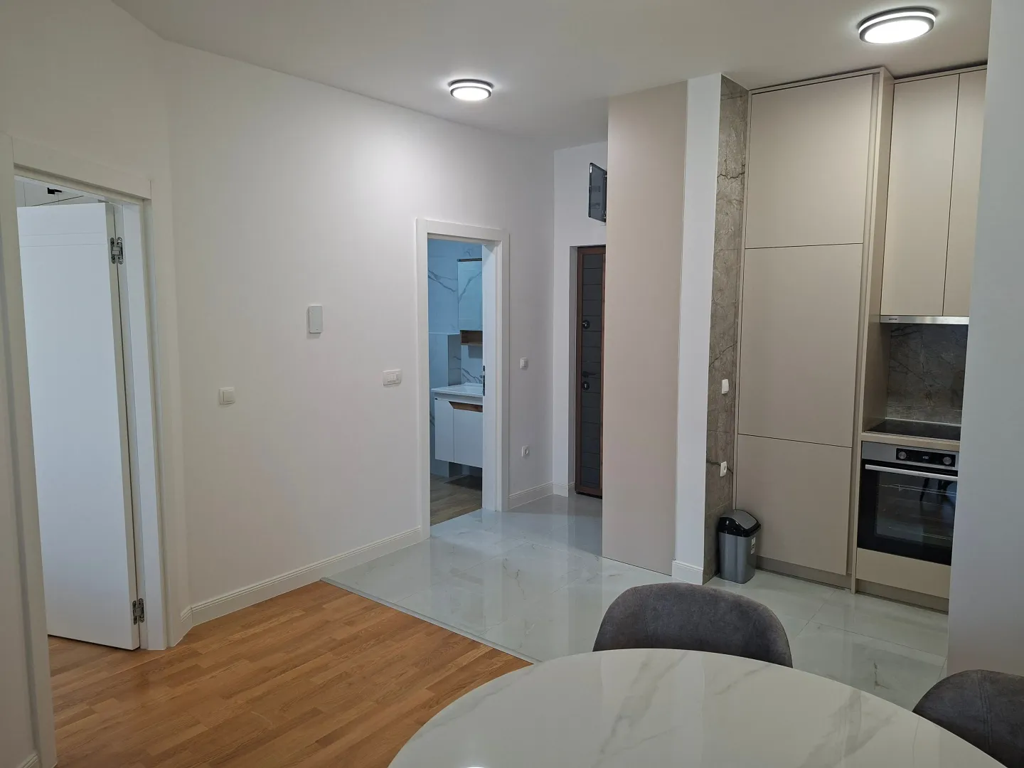 Modern kitchen with built-in appliances and dining table.