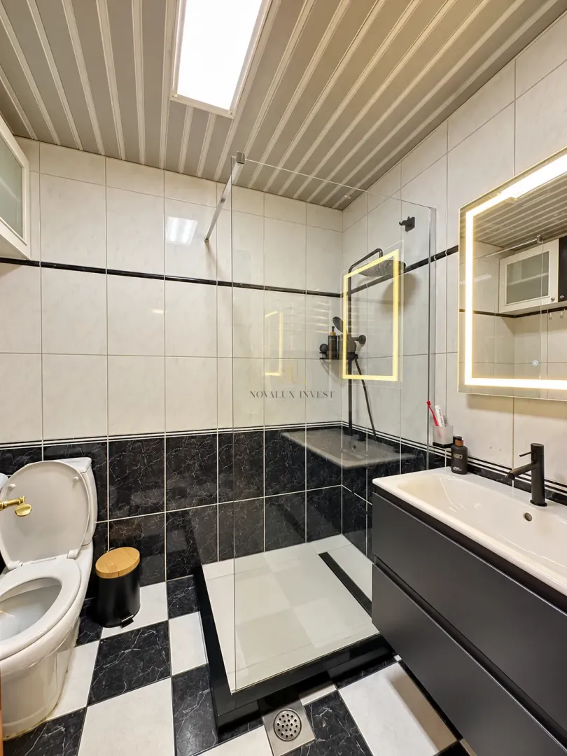 Moderne kupatilo sa tuš kabinom, umivaonikom i wc šoljom.