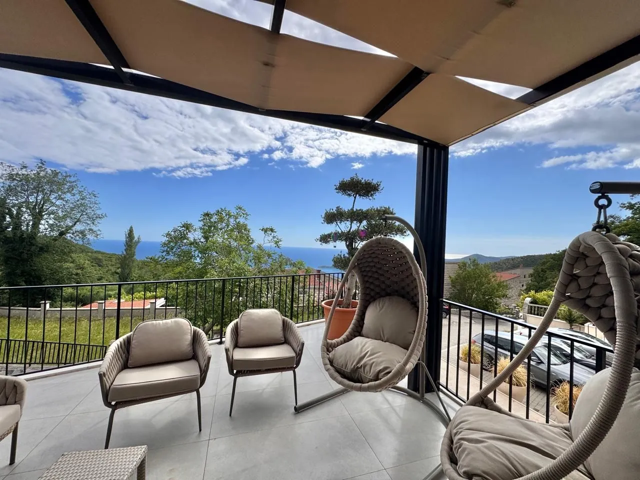 Covered terrace with seating furniture and a sea view.