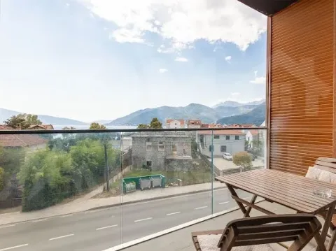 Namješten balkon sa drvenim stolom i stolicama i pogledom na more i planine. - image 18