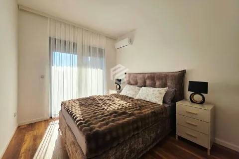 Furnished bedroom with a double bed, bedside tables, and balcony doors. - image 7