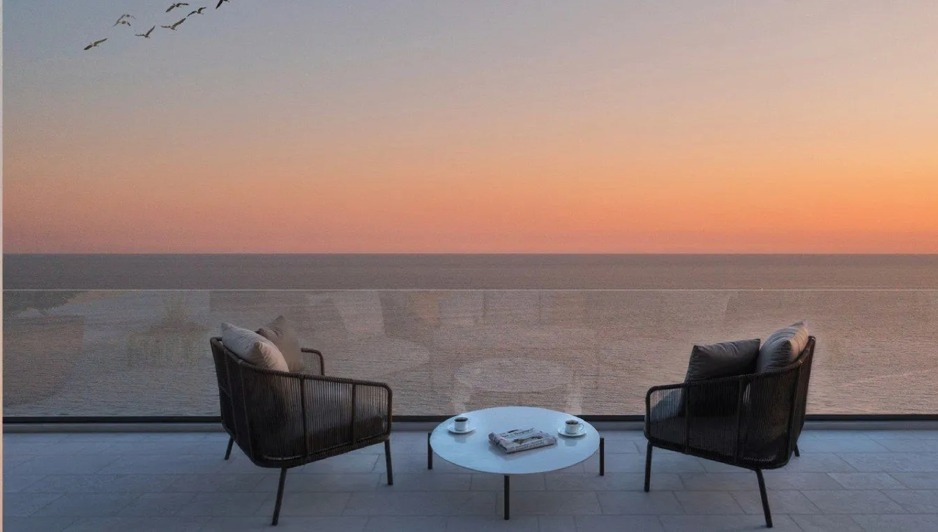 Modern terrace with seating furniture and sea view at sunset.