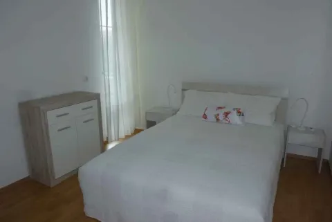 Svijetla spavaća soba sa bračnim krevetom i komodom. - image 5