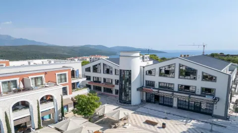 Pogled iz vazduha na moderne zgrade sa trgom i okolnim pejzažem. - image 16