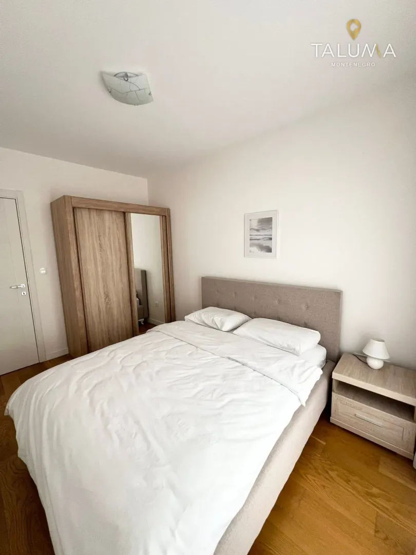 Furnished bedroom with a double bed, wardrobe, and nightstand.