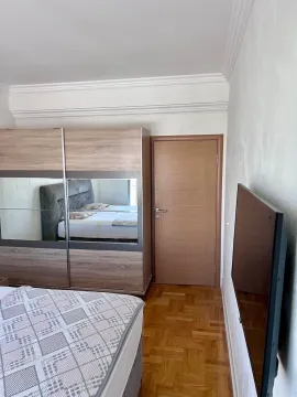 Spavaća soba sa bračnim krevetom, garderoberom sa ogledalom i televizorom na zidu. - image 8
